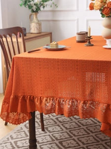 Detailed macro view of orange lace tablecloth with vintage crochet patterns and ruffles