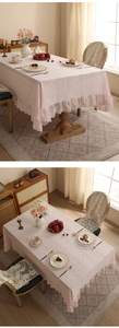 Detail of light pink lace tablecloth featuring elegant ruffled edges and floral texture