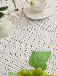 Detailed view of white lace tablecloth featuring geometric hollow embroidery patterns