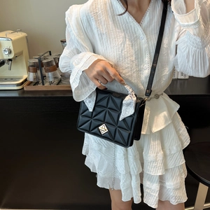Quilted black shoulder bag with golden lock and decorative silk scarf handle