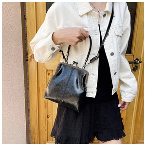Chic black shell bag with glossy finish shown being worn with a casual street style outfit