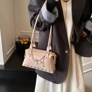 Pink trendy tote bag with pearl chain and metallic studs shown on a female model
