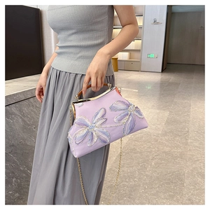 Detail showing elegant purple embroidery flowers and vintage metal frame clasp with chain