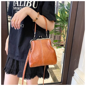 Detail of vintage brown leather shell bag with metal frame clasp and handle
