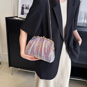Iridescent sequin shell bag with chain strap and rhinestone clasp shown on a model
