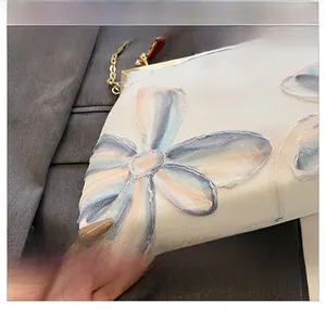 Macro detail of 3D floral organza embroidery with colorful gradient edges on white mesh bag