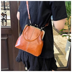 Detail of vintage brown leather handbag with silver ball clasp and contrast stitching