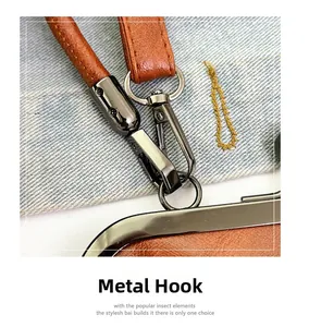 Detail of dark gray metal hook and stitching on dark brown leather handbag handle