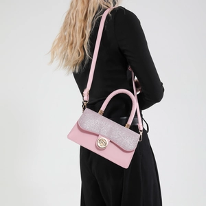 Pink vintage leather crossbody bag with sequin flap and gold lock shown on model