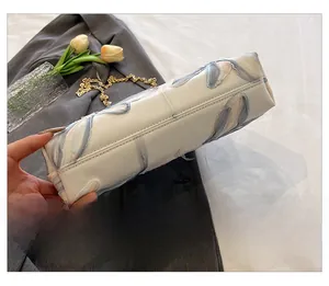 Detail showing the bottom structure and stitching of the floral light blue chain bag