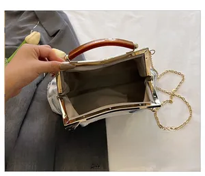 Detail view of the floral evening bag interior with amber resin handle and metal clasp