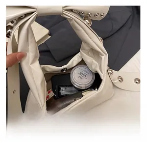 Interior view of the cream shoulder bag showing capacity for phone and cosmetics