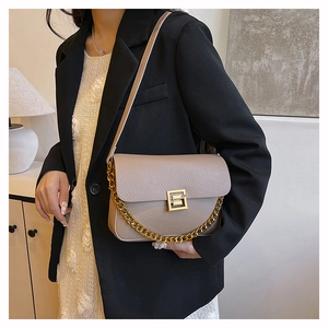 Close-up of beige lychee grain leather bag with vintage gold square lock and chain
