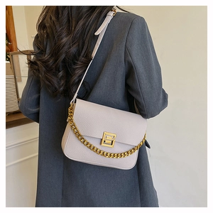 Detail of lilac lychee grain leather bag featuring a gold square clasp and chain strap