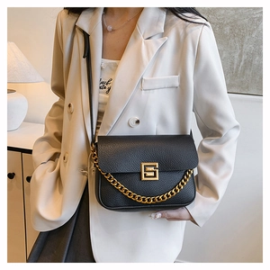 Detail of black lychee grain leather bag with gold G-lock and thick decorative chain