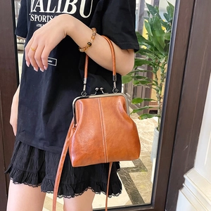 Brown leather shell handbag with metal clasp and contrast stitching detail