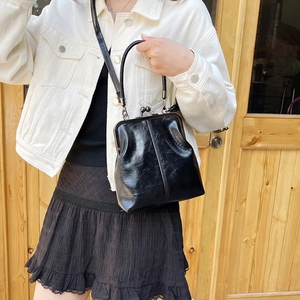Glossy black vintage shell handbag with metallic clasp and adjustable strap for women