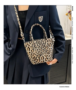 Close-up of leopard print tote bag with round handles and adjustable silver strap buckle