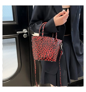 Dettaglio mini borsa a secchiello leopardata rossa e nera con tracolla staccabile