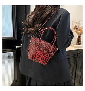 Fashionable red leopard print mini shell bag styled on a navy blue suit jacket