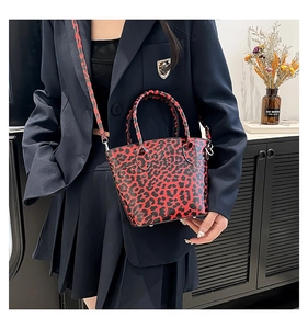 Detail of red and black leopard print handbag with silver hardware and leather straps