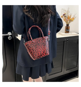 Detail of red and black leopard print bucket bag with detachable crossbody strap