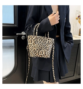 Detail view of fashion leopard print bucket bag with metal studs and top handle