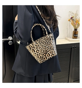Rear view of a model wearing the leopard print shell bag with top handle and crossbody strap