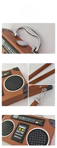 Detail view of radio-shaped bag with silver metal handle, lock, and retro dials