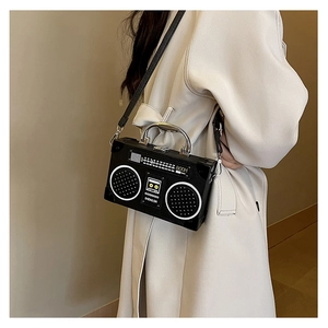 Macro detail of retro radio-shaped crossbody bag with metal handle and vintage dial print