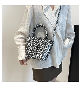 Close-up of leopard print mini bucket bag with silver hardware and adjustable strap