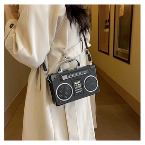 Detail of vintage radio-shaped crossbody bag featuring textured black faux leather