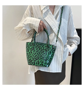 Detail view of green leopard print tote bag with synthetic leather handles and strap