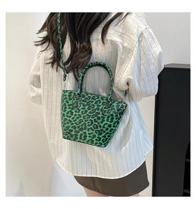Close-up of green leopard print bucket bag with matching handles and crossbody strap