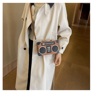 Macro detail of retro radio shaped crossbody bag with vintage boombox patterns and strap