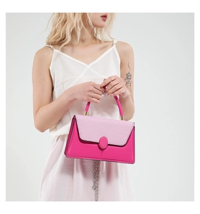 Detail of elegant two-tone handbag with rose pink smooth leather and woven flap texture