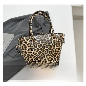 Detail of leopard print tote bag with glossy finish, dual handles and crossbody strap