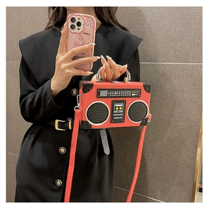 Detail of red vintage radio-shaped crossbody bag with realistic dial and speaker design