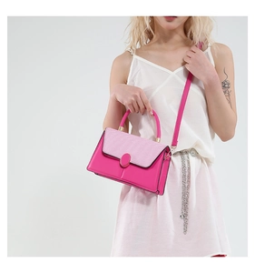 Close-up of bright pink crossbody bag with faux snake pattern flap and metal buckle