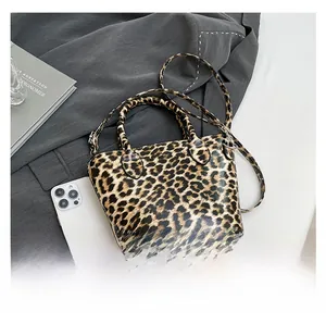 Detailed top view of leopard print crossbody bag with handles and adjustable strap