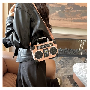 Detail of creative pink radio-shaped shoulder bag featuring retro dials and silver handle