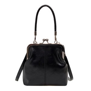 Vintage black shell-shaped handbag with metallic frame closure and adjustable strap