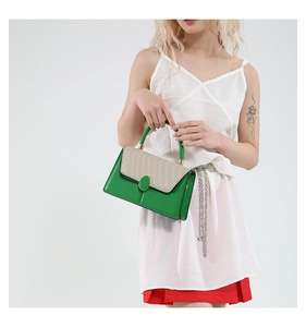 Detail view of contrast color handbag with green leather and beige woven flap design