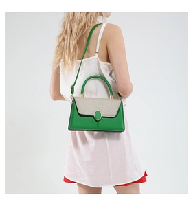 Close-up of bright green and beige embroidered tote bag worn by a model in a studio