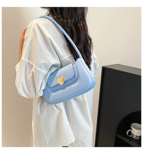 Dettaglio della borsa sottospalla in ecopelle celeste con fibbia dorata a forma di cuore