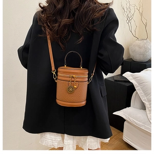 Detailed view of a vintage brown leather bucket bag with gold hardware and logo charm