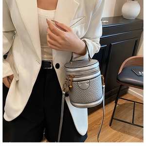 Silver embossed leather bucket bag detail with gold hardware and stylish top handle