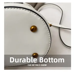 Detailed macro view of white leather bucket bag base with protective gold metal studs