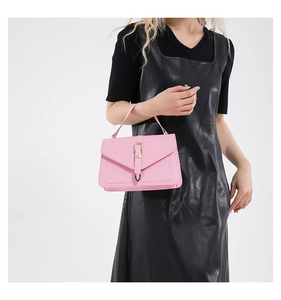 Detailed view of a pink envelope handbag with textured leather and metal buckle
