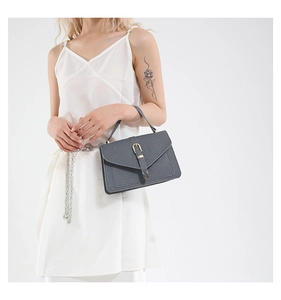 Detailed shot of dark grey crossbody bag with belt buckle and crosshatch texture